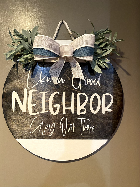 Like a Good Neighbor Stay Over There handmade wooden door hanger with bow